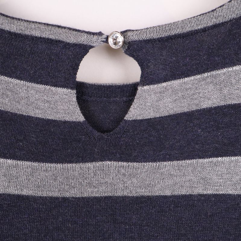 Knappdetalj och droppformad öppning i nacken