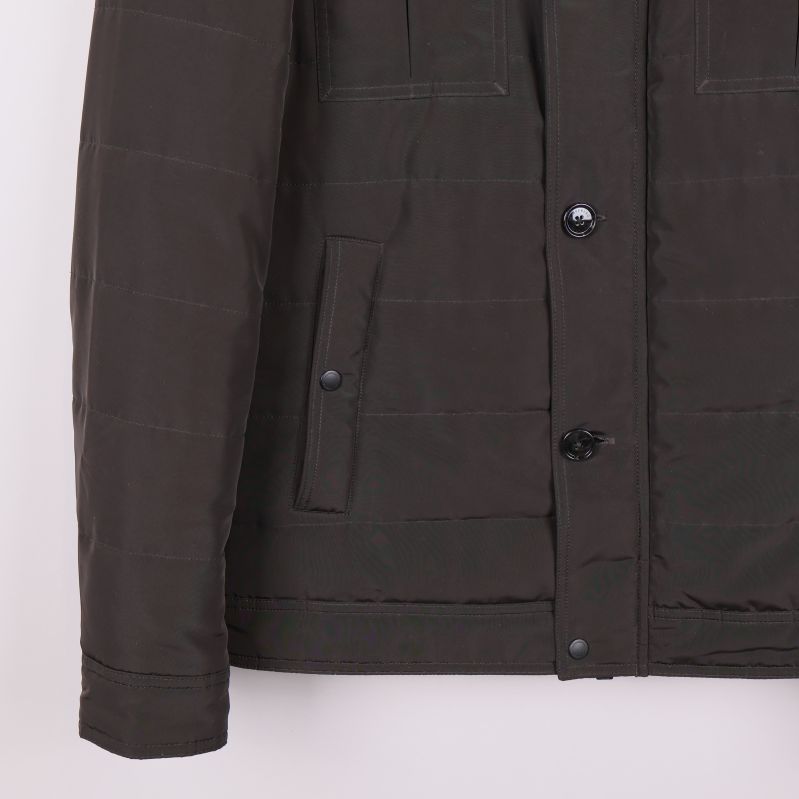 Närbild på jackans ena ficka med knapp