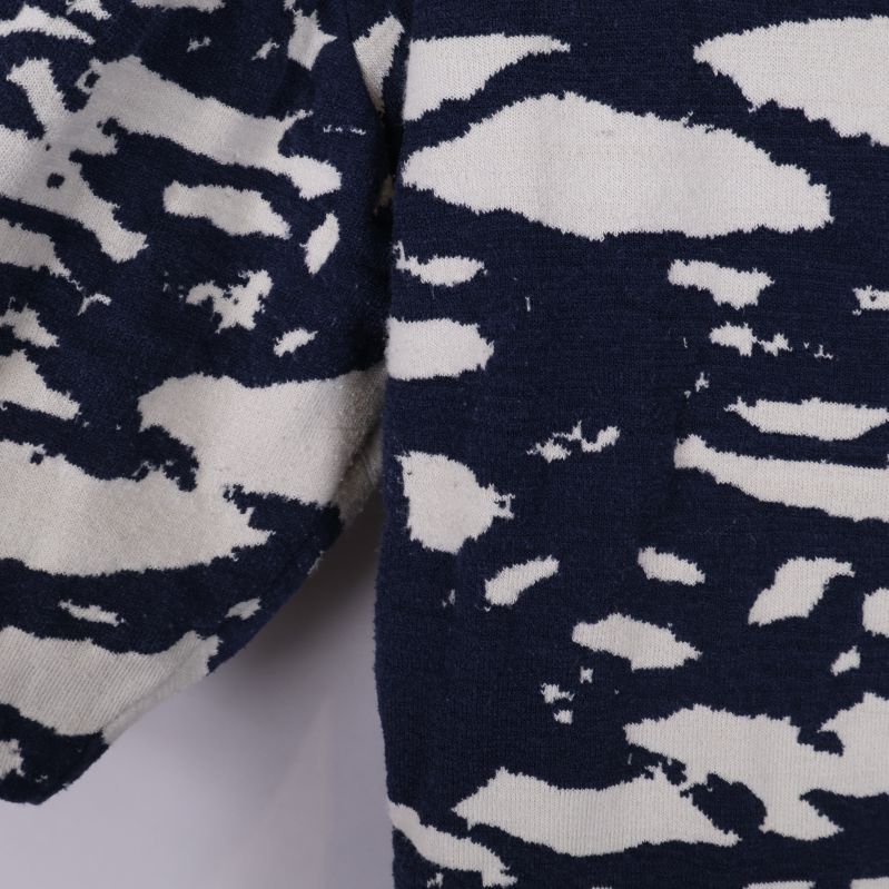 Närbild på klänningens ärm med grafiskt blåvitt mönster