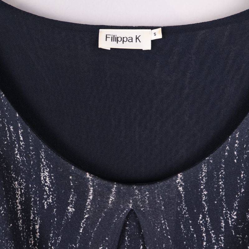 Närbild på halsringning och etikett från Filippa K