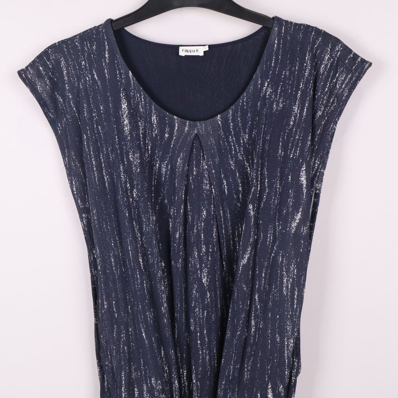 Närbild på överdel och axelparti på mönstrad klänning