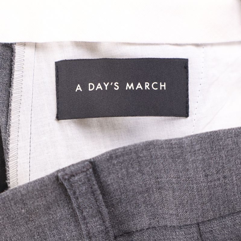 Närbild på varumärkesetikett A Day's March i byxlinning