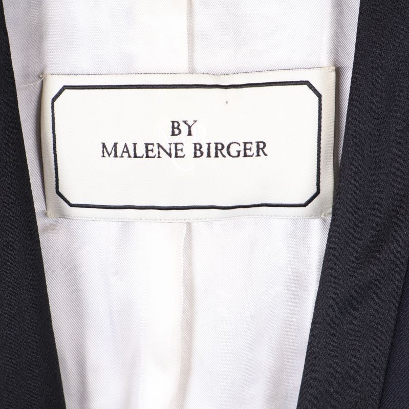 Närbild på vit etikett med texten By Malene Birger