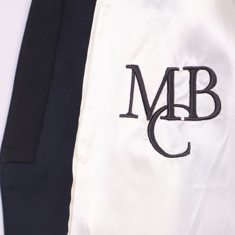 Vit foderdetalj med broderat monogram MBC