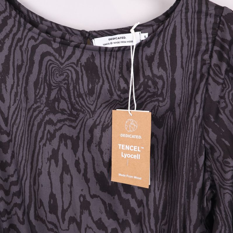 Närbild på TENCEL tag med varumärkesetikett vid halsen