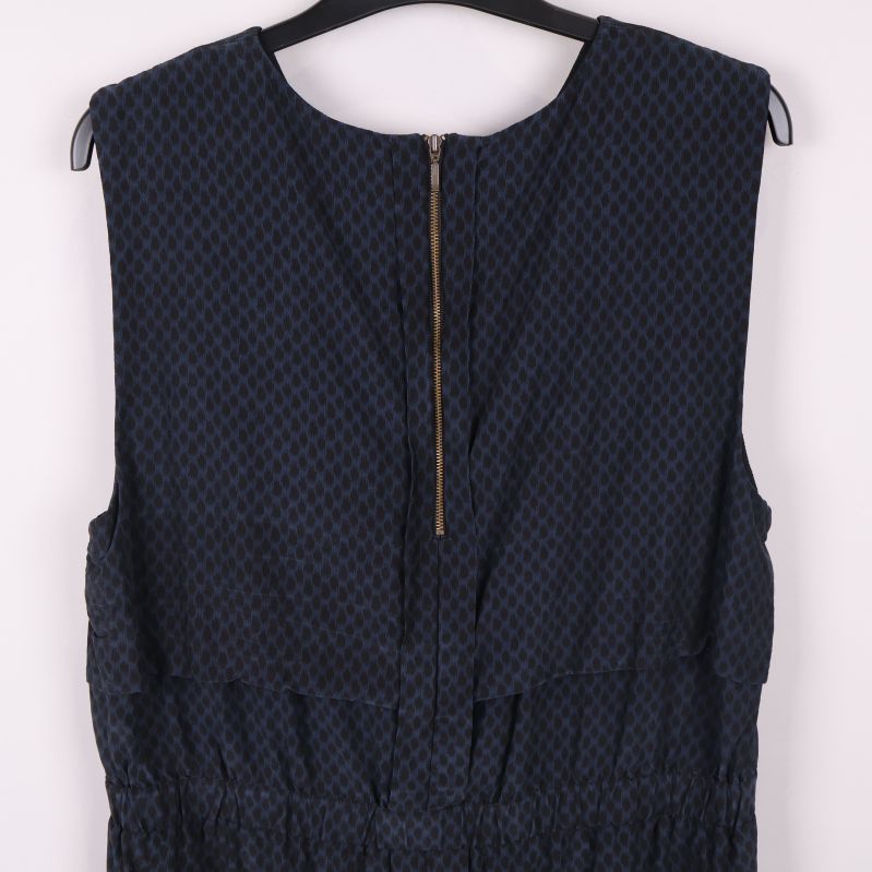 Närbild på övre ryggparti och guldig dragkedja