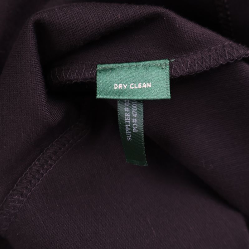 Grön tvättanvisningstagg med texten Dry Clean