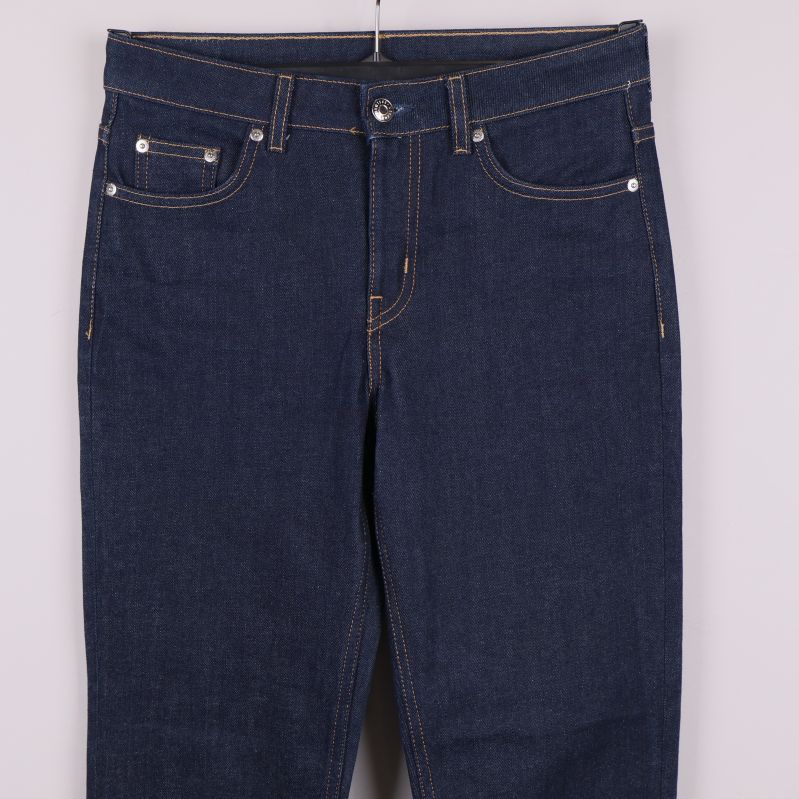 Närbild på midja och framfickor på mörkblå jeans