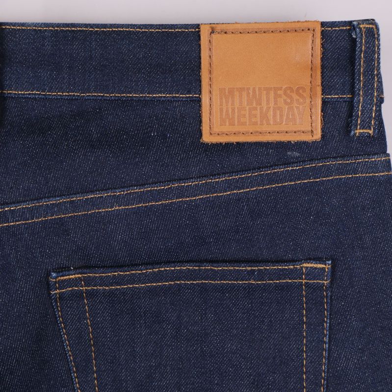 Närbild på bakficka och läderpatch med Weekday-logga