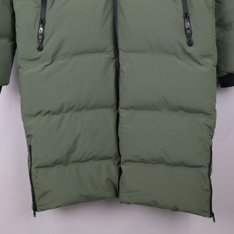 Nederdel av grön parkas med slitsar