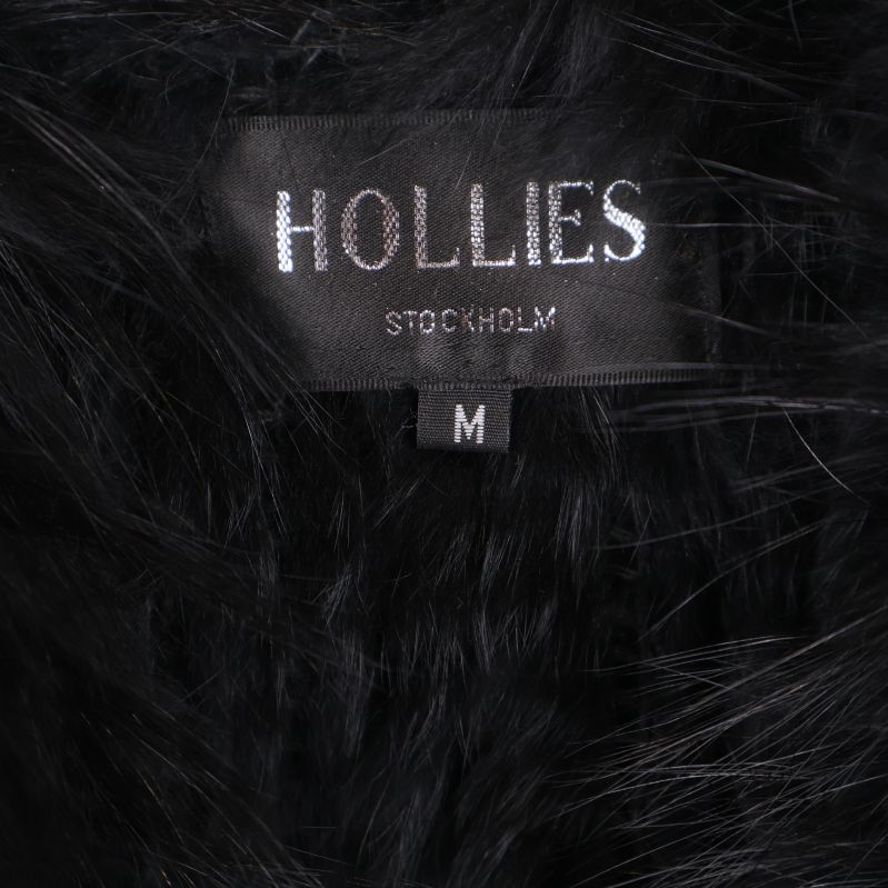 Närbild på Hollies Stockholm-märke på svart pälsväst