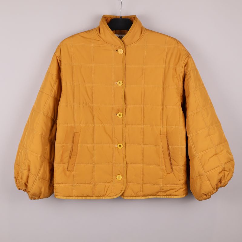 Quiltad jacka med rund krage och stora knappar framifrån