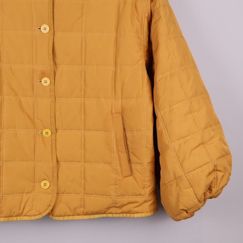 Närbild på fickor och nederdel av quiltad jacka