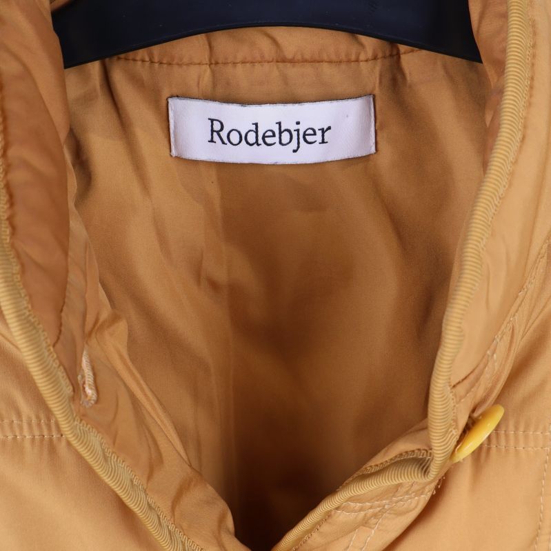 Närbild på etikett med Rodebjer-loggan i kragen