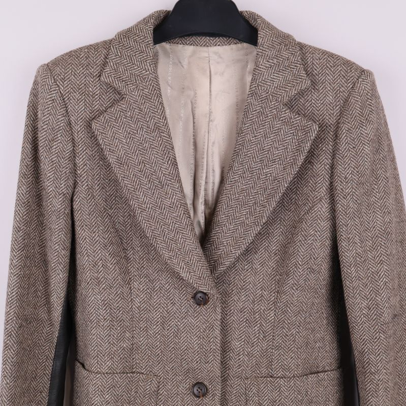 Närbild på krage och axel på fiskbensmönstrad blazer