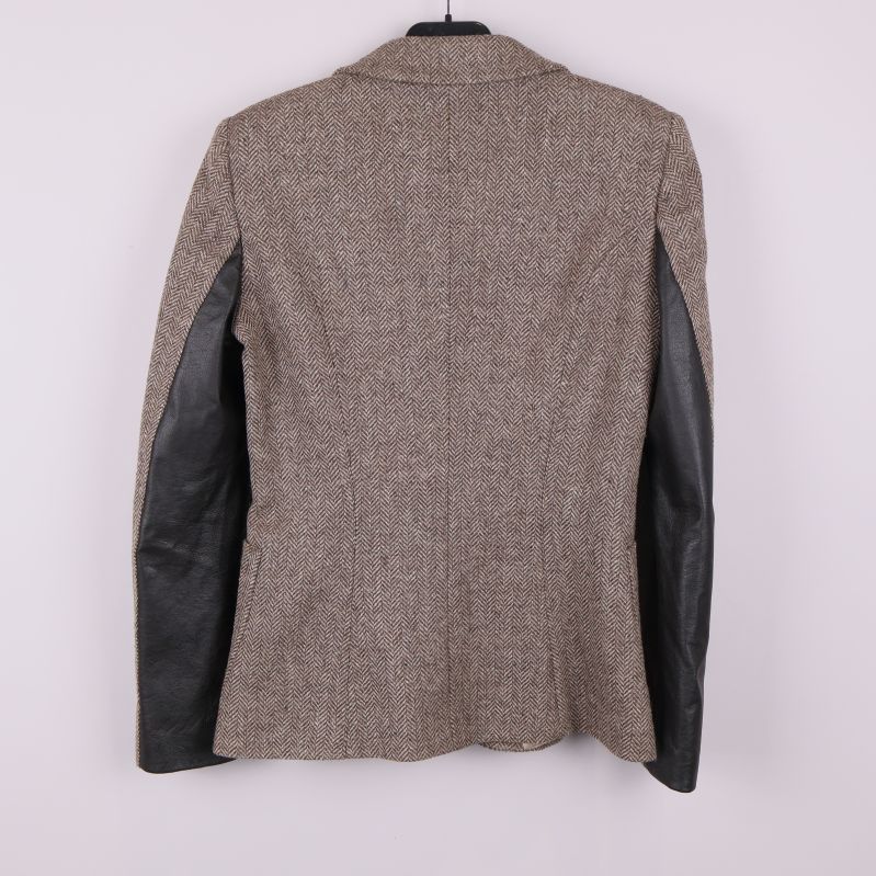 Baksida av blazer med svarta skinnpaneler på armarna