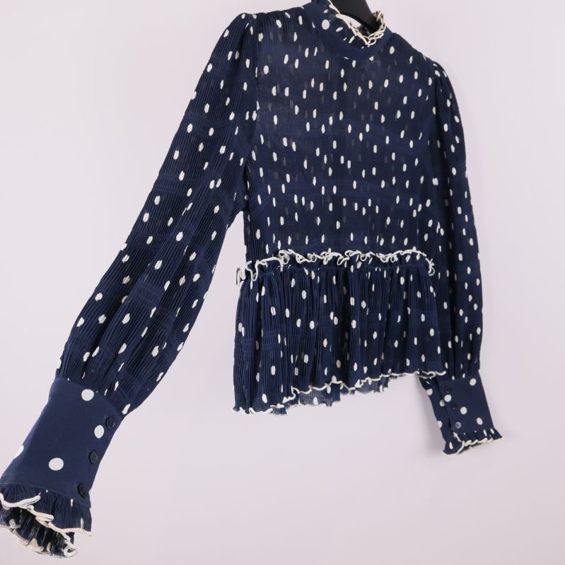 Sned vy av blus med plisserat tyg och prickigt mönster