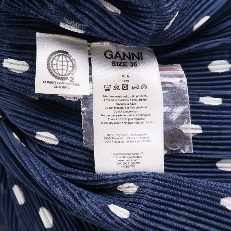 Materialetikett Ganni blus med information om polyester