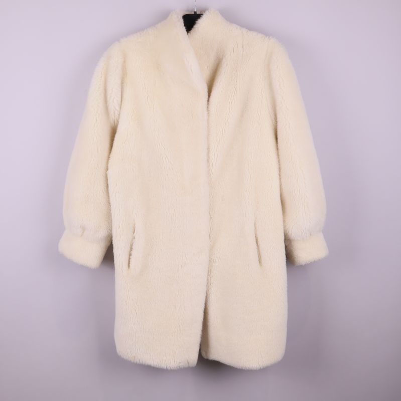 Framsidan av vit pälsliknande vintagekappa med fickor och ärmar