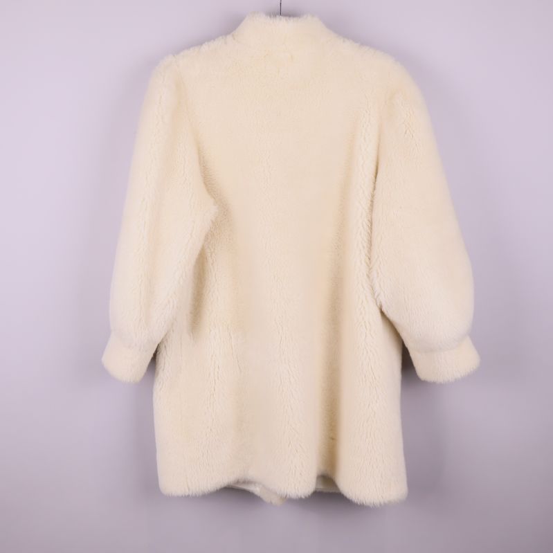 Baksidan av vit luddig vintagekappa med puffärmar