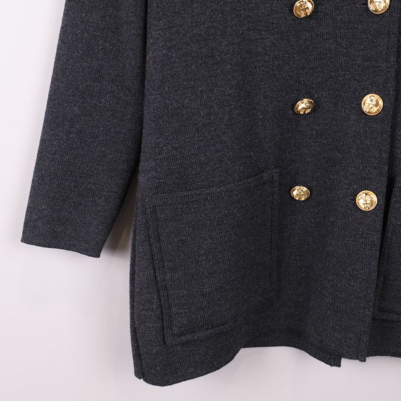 Närbild på nedre del av kavaj med fickor och knappar