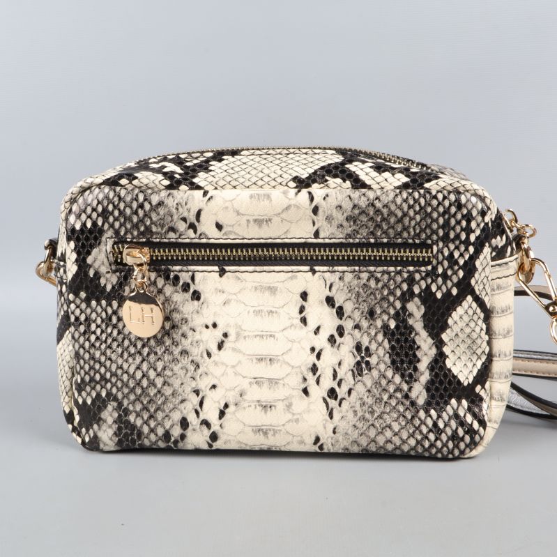 Andra sidan av väska med ormmönster, fokus på dragkedja och rem