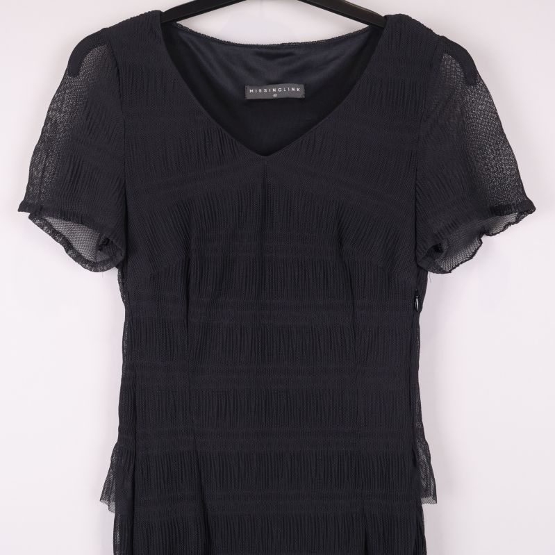 Övre delen av svart klänning med transparenta ärmar