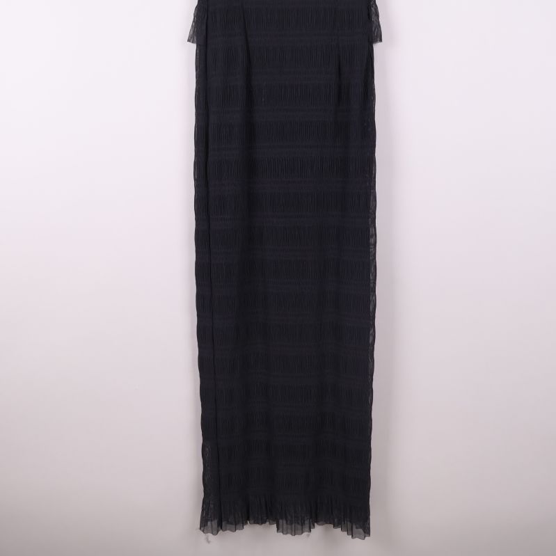 Nedre delen av lång svart klänning i transparent tyg