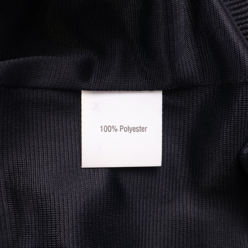 Materialetikett som visar 100% polyester