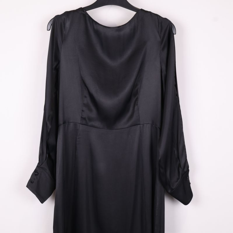 Närbild på lång ärm och överdelen av svart klänning