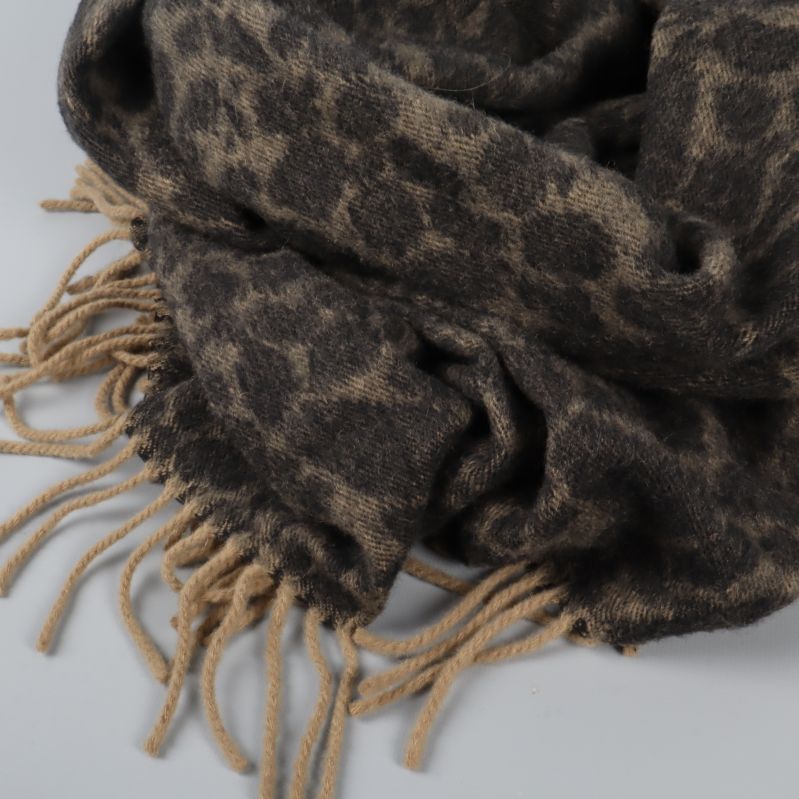 Närbild på rundad halsduk med fransar och leopardmönster