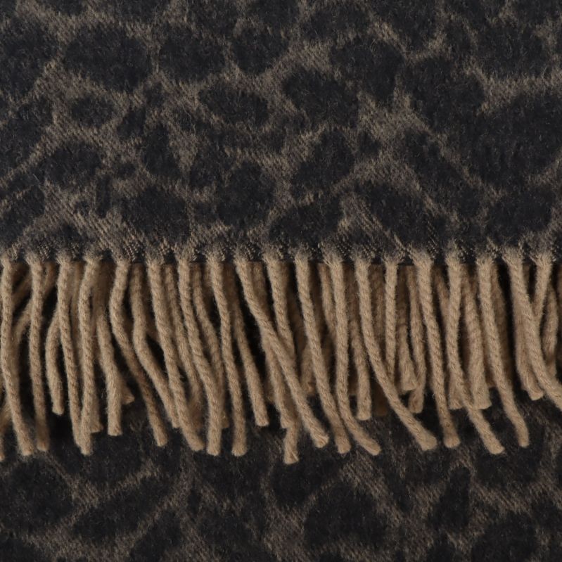 Närbild på beige fransar och leopardmönstrad textur