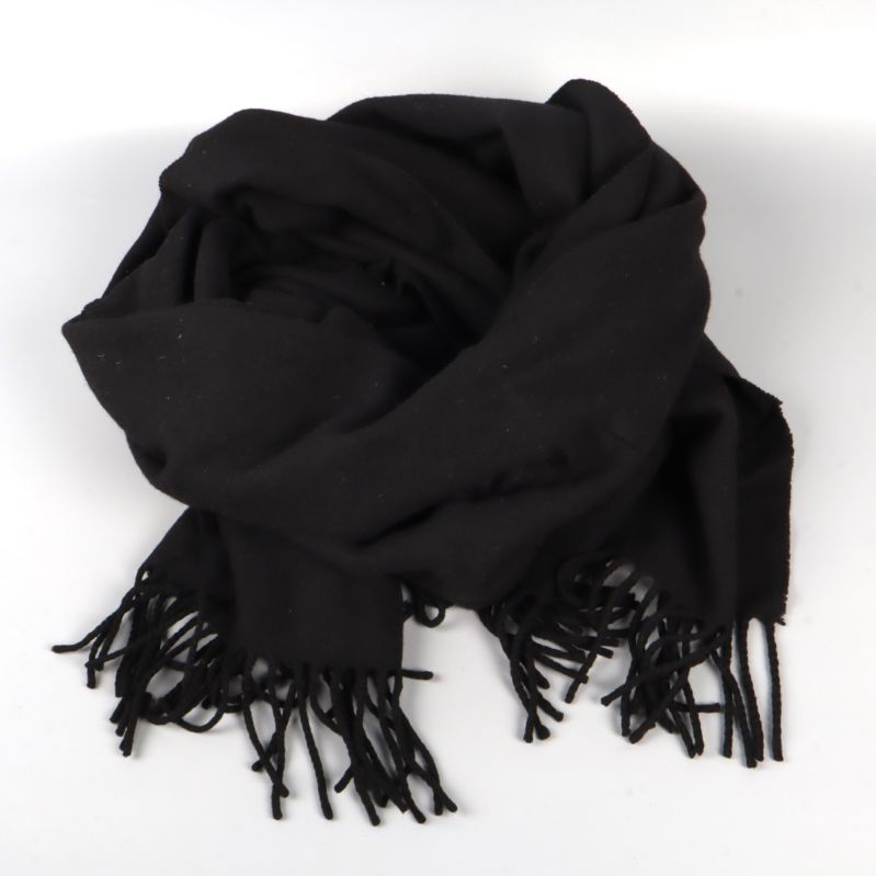 Svart halsduk med fransar vikt i en hög