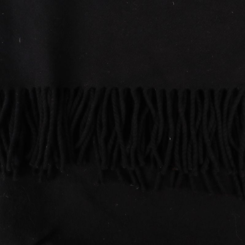 Närbild på fransar i svart ulltyg