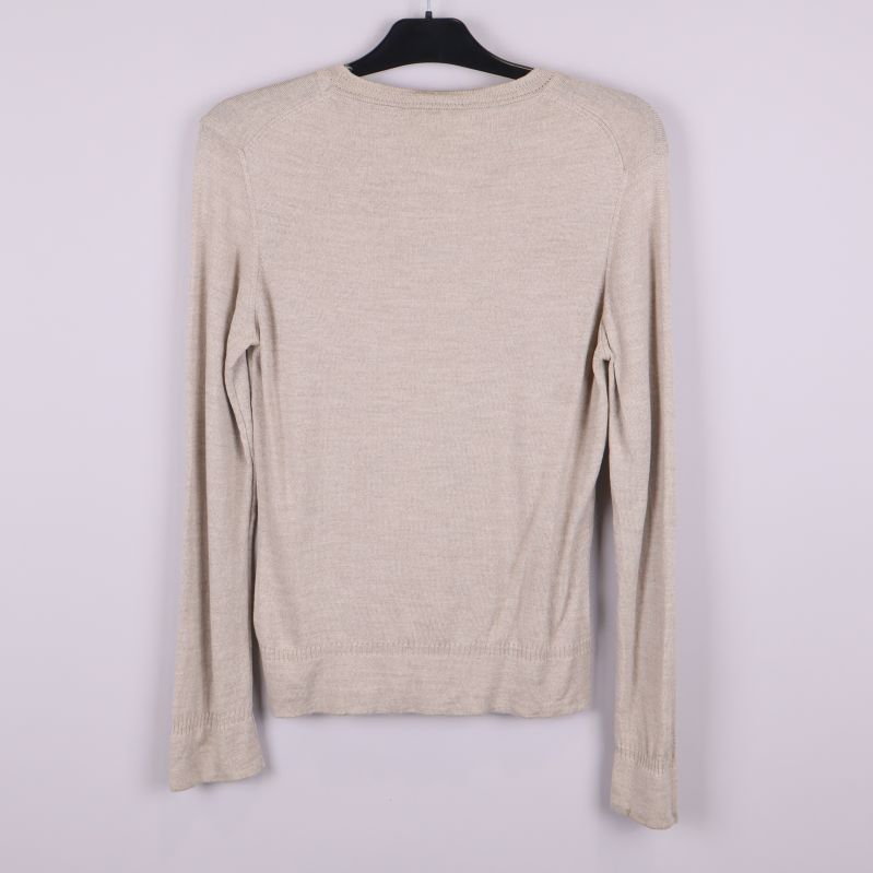 Baksidan av beige långärmad kofta