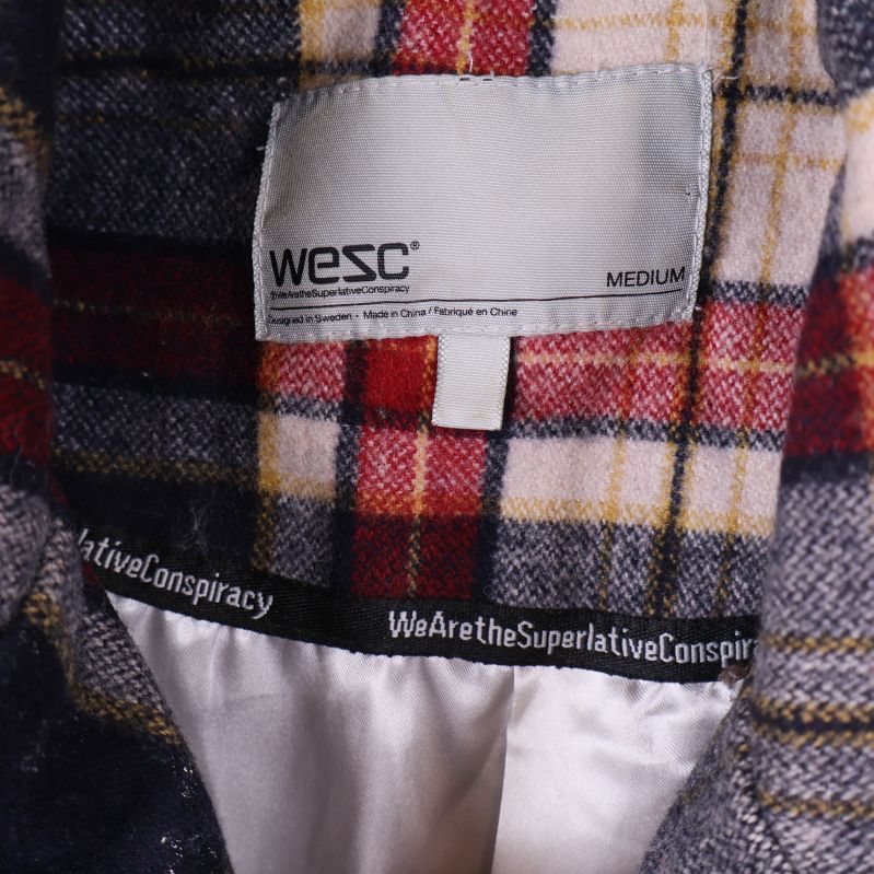 Närbild på Wesc-märkeslapp samt insida av kappan