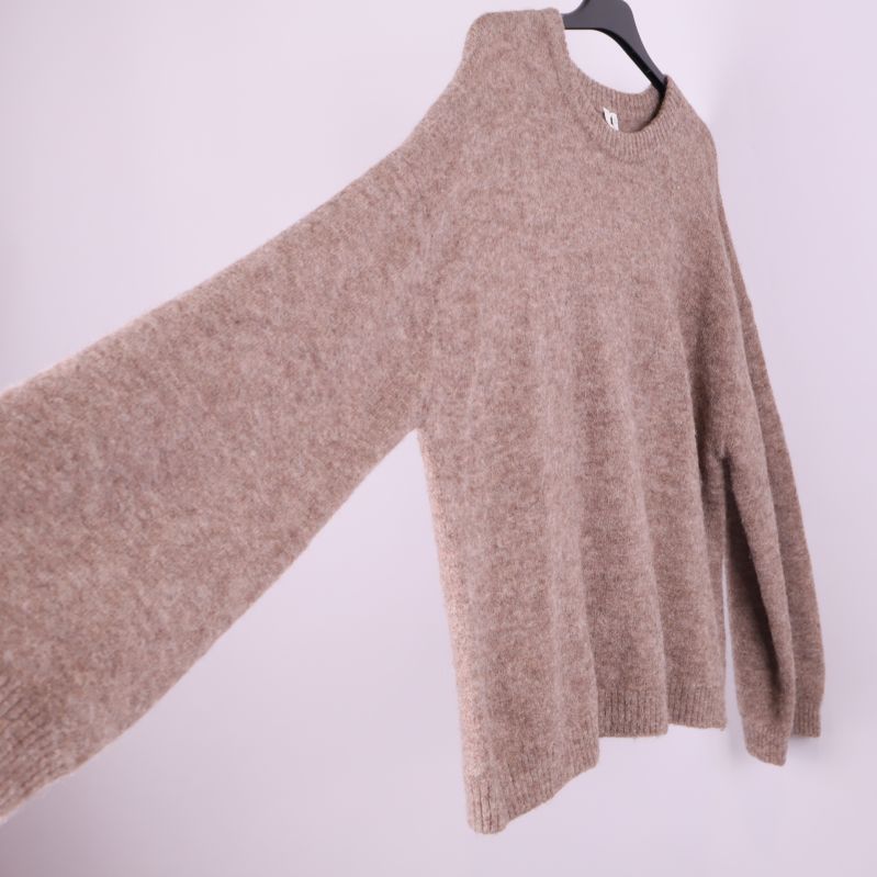 Beige stickad tröja med utsträckt ärm från sidan