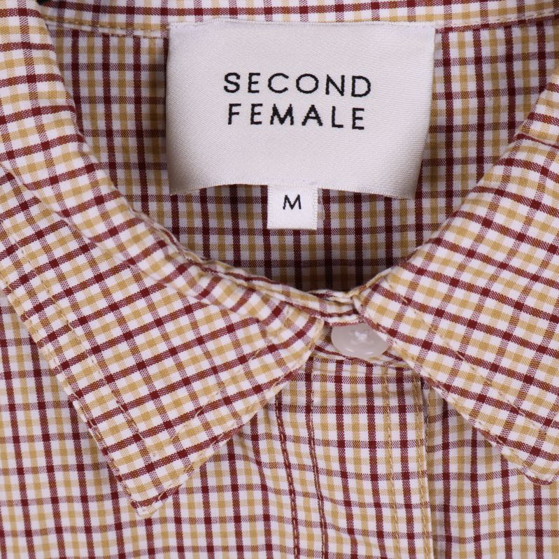Närbild på kragen med Second Female-märke