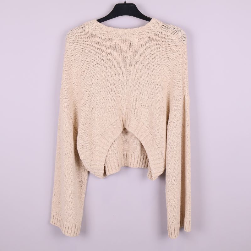 Stickad beige tröja upphängd bakifrån