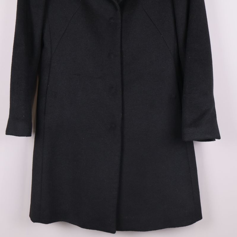 Kappans nedre del visas i närbild mot ljus bakgrund