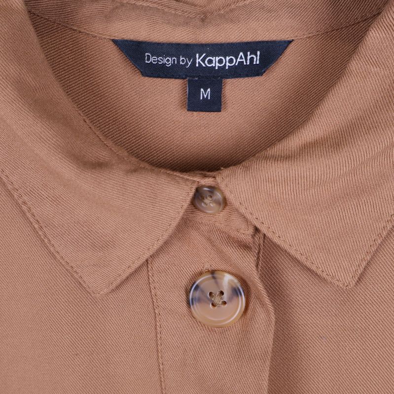 Närbild på krage och knapp samt KappAhl-märkning