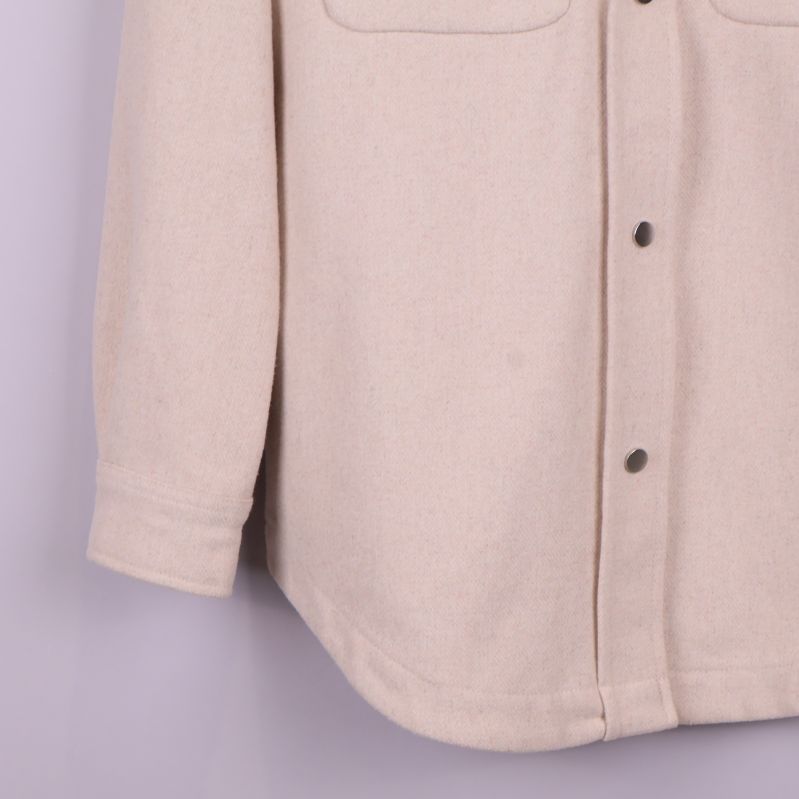 Nedre delen av overshirt och ärmslut i beige tyg