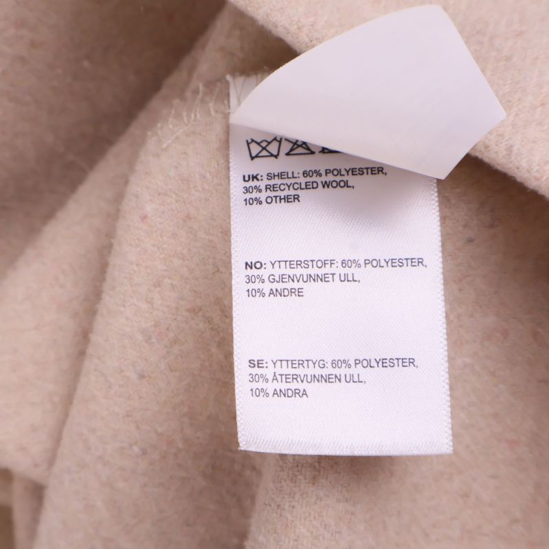 Materiallapp visar 60 procent polyester och 30 procent återvunnen ull