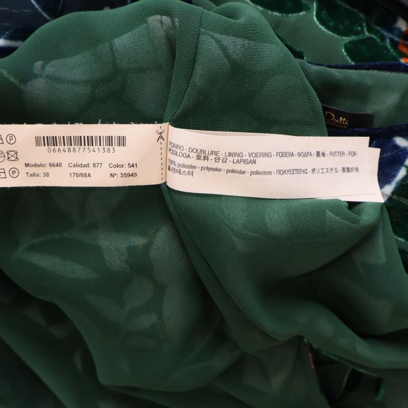 Tvättlapp med materialinformation i grön klänning