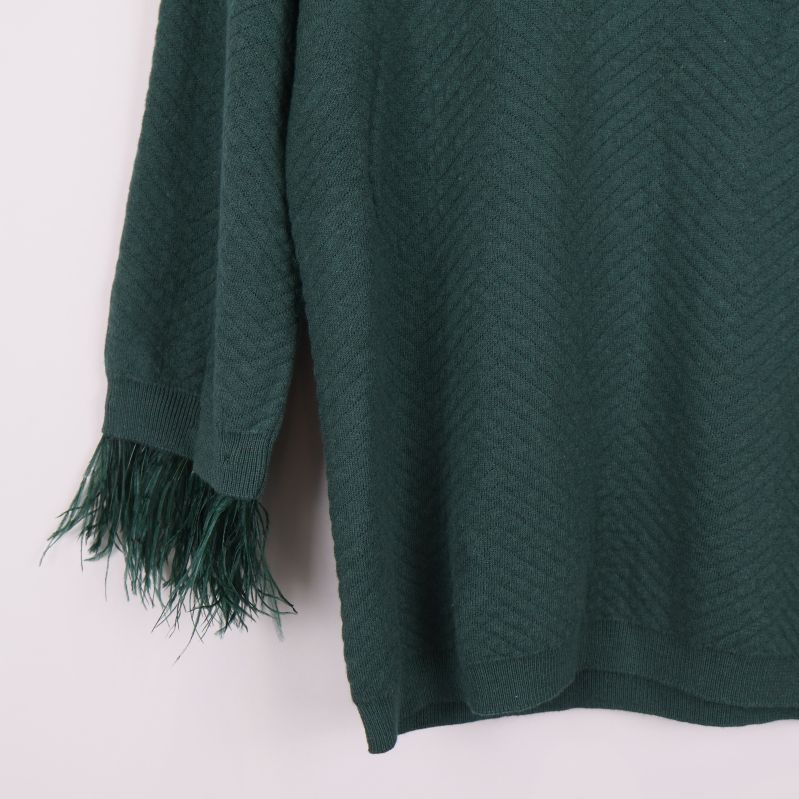 Närbild på tröjans fransade ärmslut till vänster