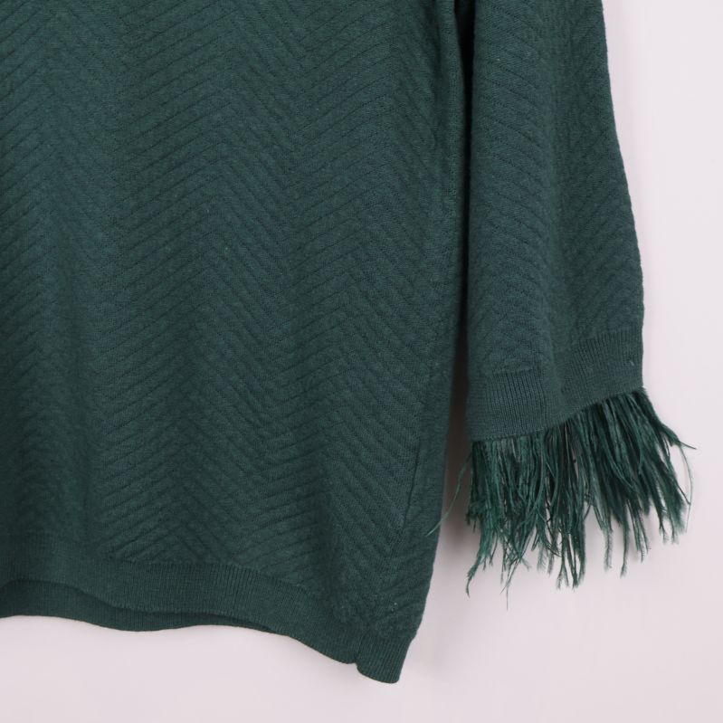 Närbild på tröjans fransade ärmslut till höger