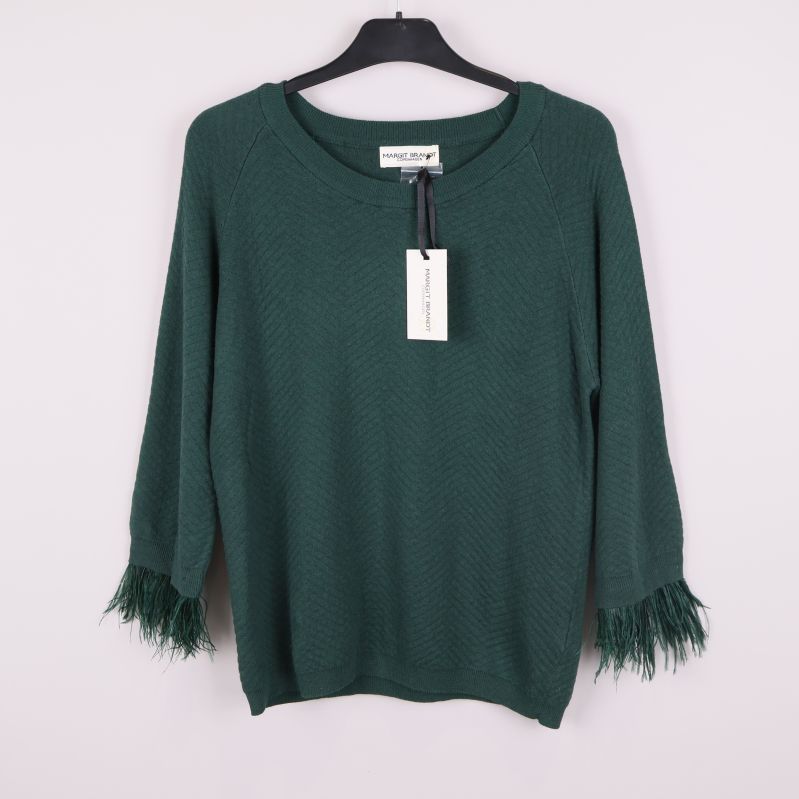 Mörkgrön stickad tröja med fransar på ärmarna framtill