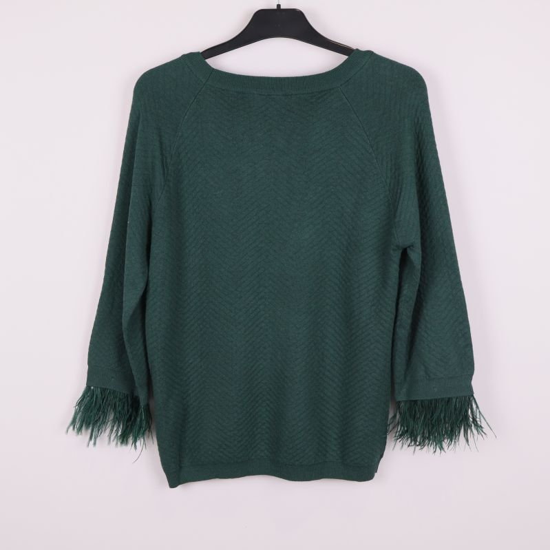 Mörkgrön stickad tröja med fransar på ärmarna bakifrån
