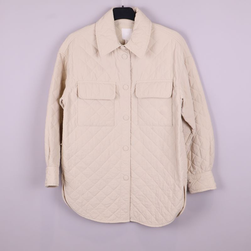 Framsida av quiltad beige overshirt med två fickor