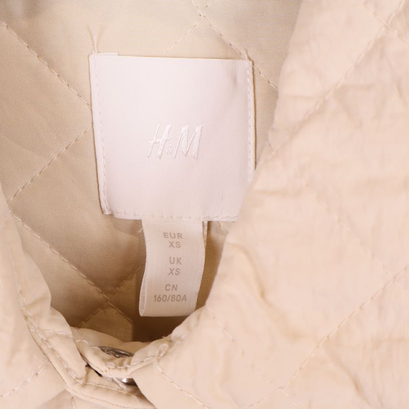 Närbild på H&M-etikett i kragen på plagget